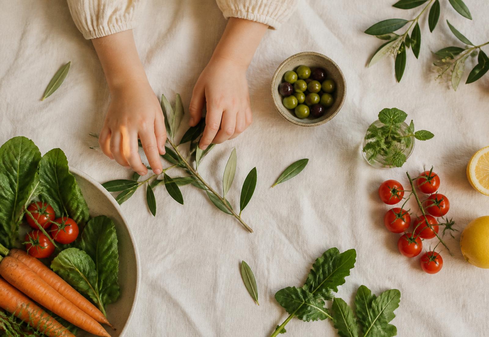 Composição editorial com folhas, tomates, azeitonas e vegetais frescos